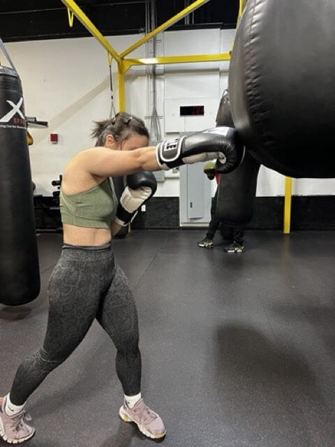 Maria, an X3 member, practicing a cross in an X3 Sports boxing class.